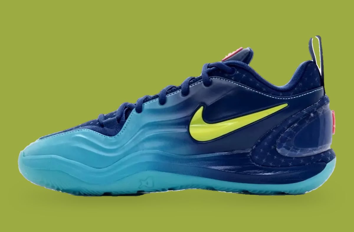 Lateral view, navy to aqua fade with neon yellow swoosh and star-pattern heel, olive backdrop, Wheels On