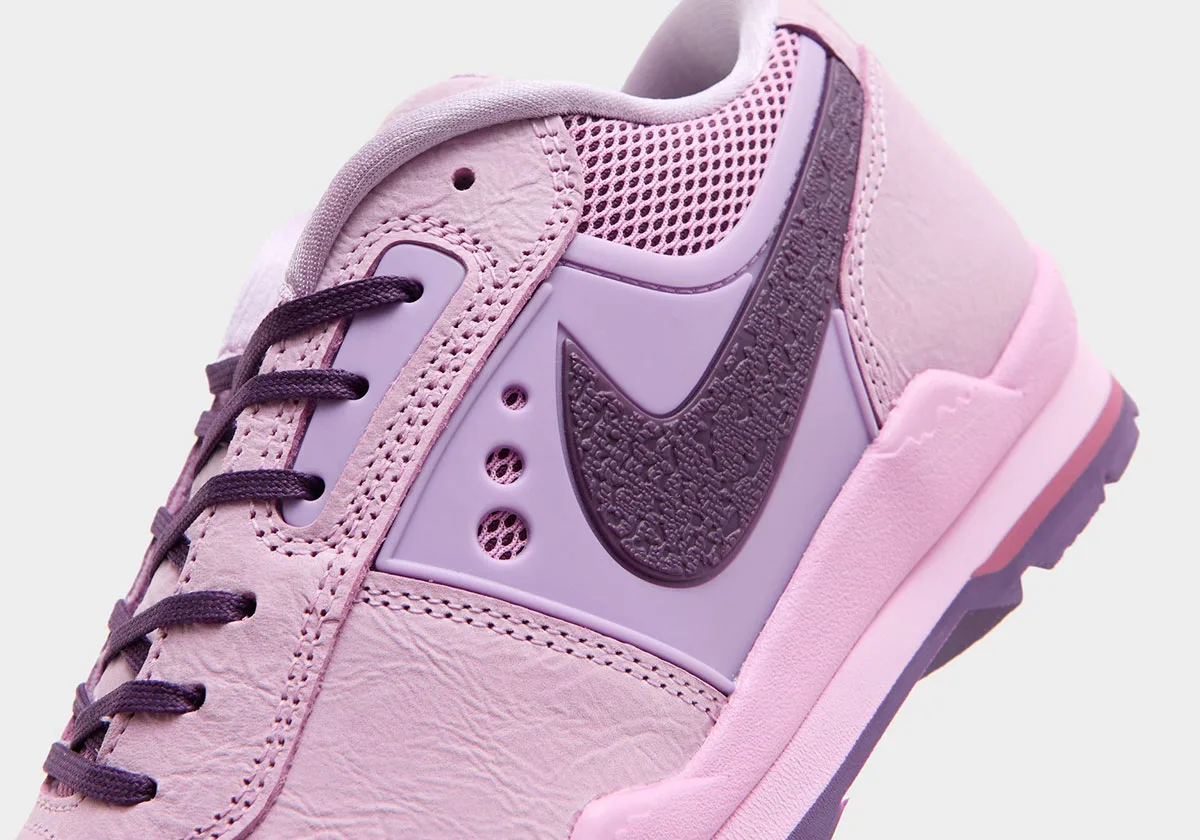 Close-up detail of pink sneaker's purple textured Swoosh on lilac panel, Nike Baltoro Low