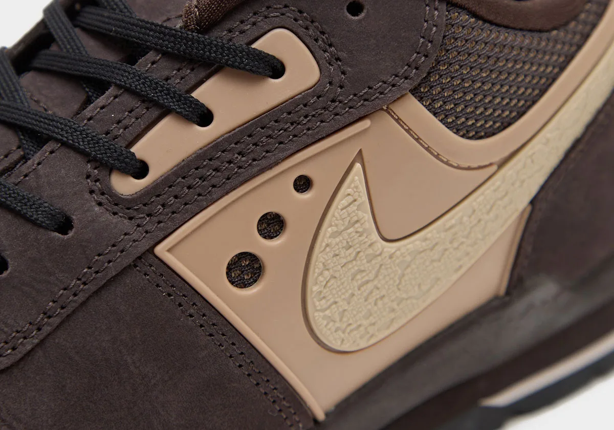 Close-up detail of brown sneaker's tan textured Swoosh, stitching and black laces, Nike Baltoro Low