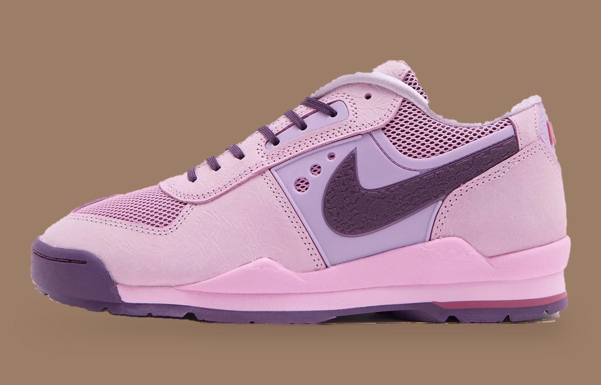 Lateral view of pink sneaker with purple textured Swoosh and lilac side panel, Nike Baltoro Low