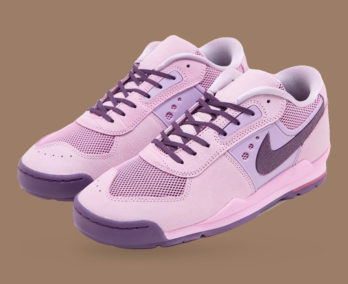 Pair of pink sneakers at an angle, purple laces and purple toe caps, Nike Baltoro Low
