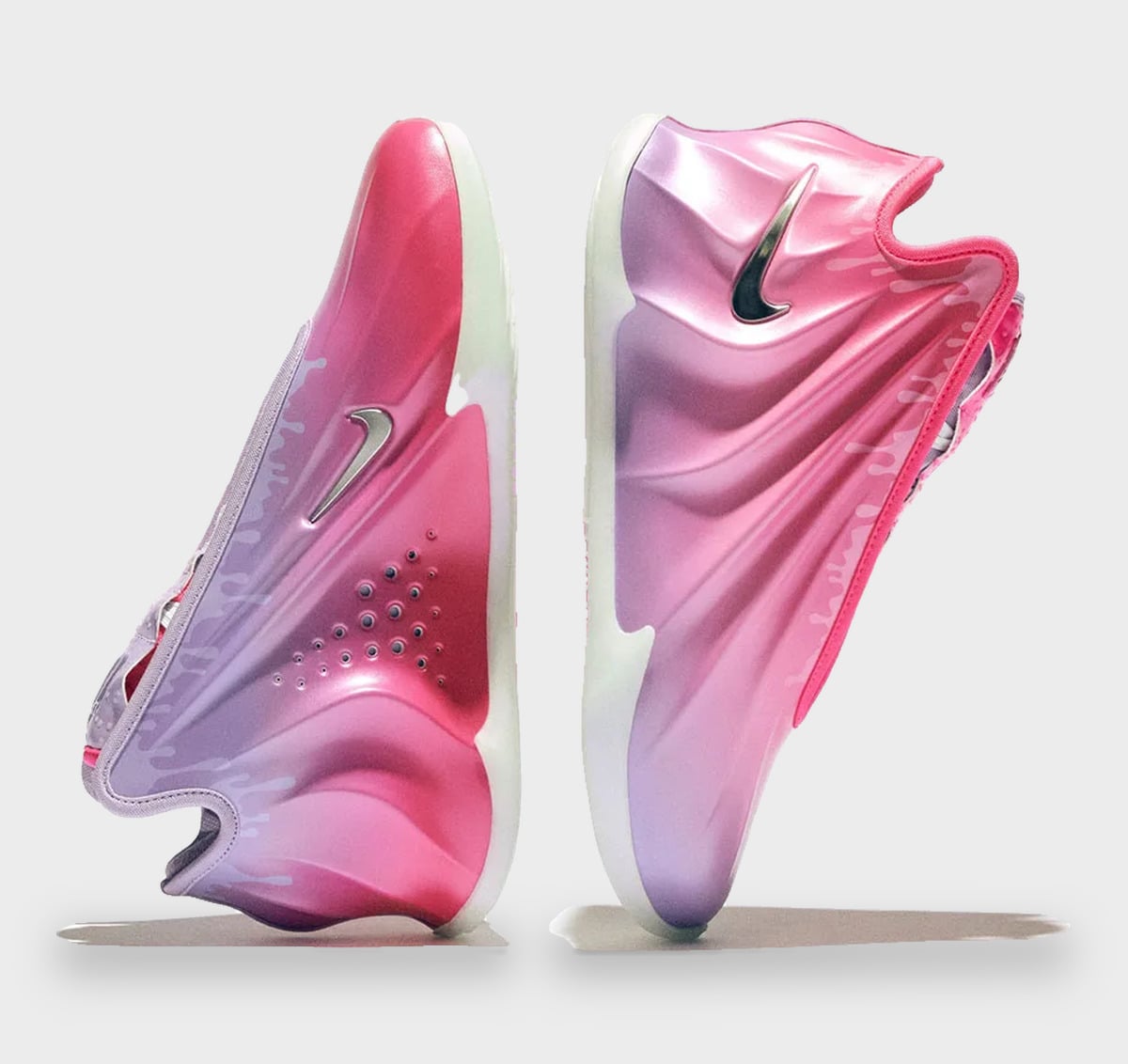 Pair standing on their sides, pink-to-lilac gradient shells with chrome swooshes and perforations, Freestyle 2027 Collection