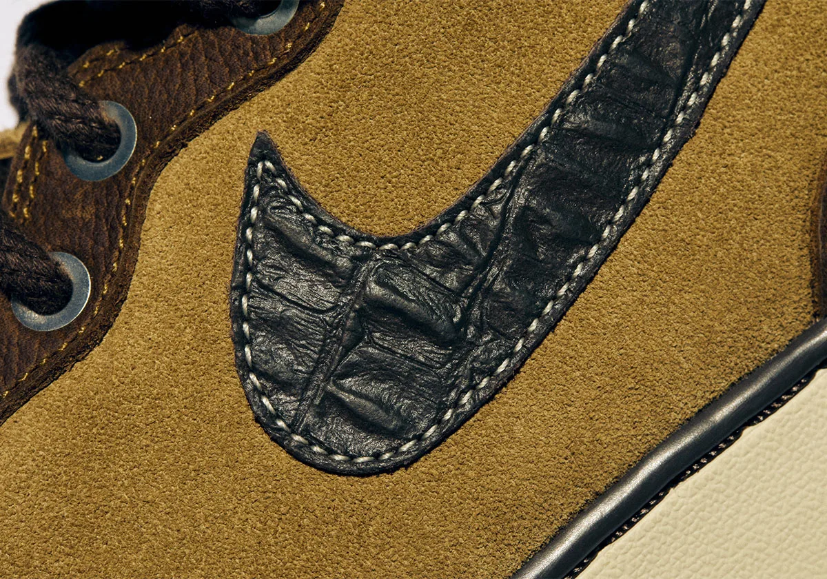 Detail of a black embossed leather swoosh with white stitching on tan suede, Freestyle 2027 Collection