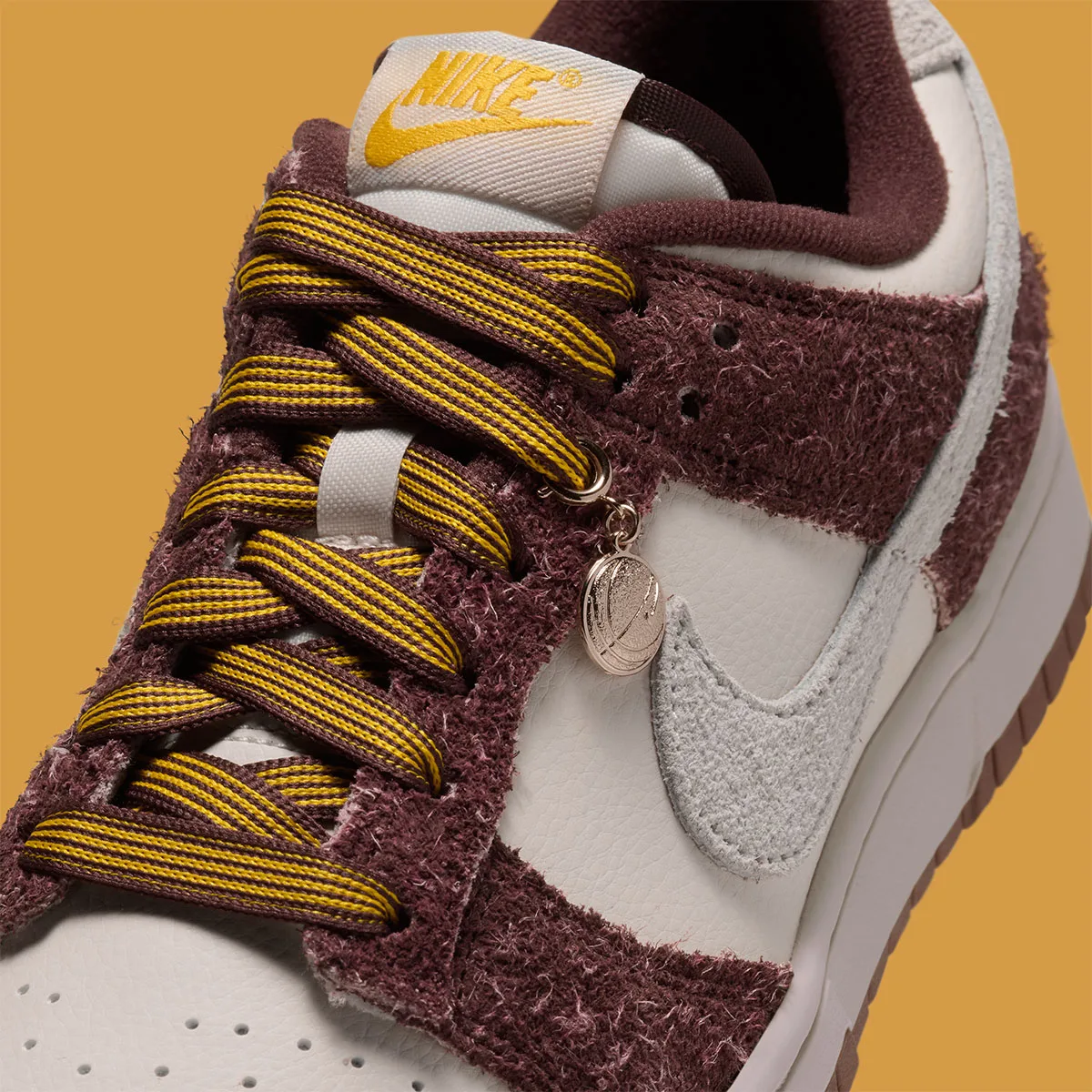 Detail of laces and tongue, gold basketball charm, striped gold laces, yellow Nike tongue label, Basketball Charm