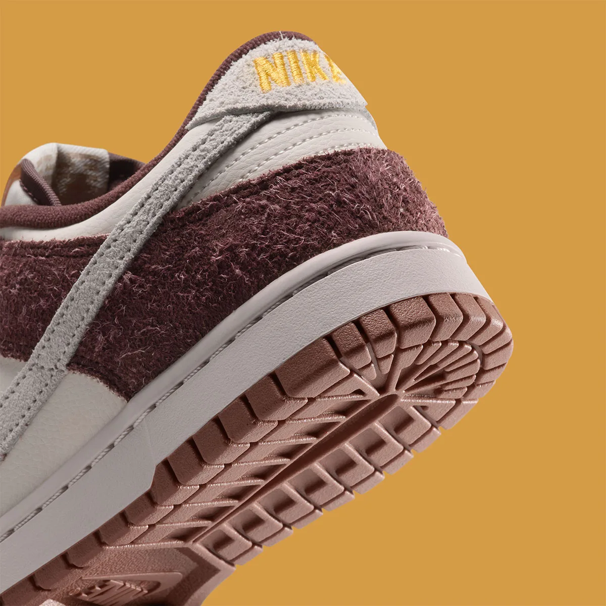 Detail of heel and outsole, yellow Nike embroidery on grey tab, burgundy shaggy suede, Basketball Charm