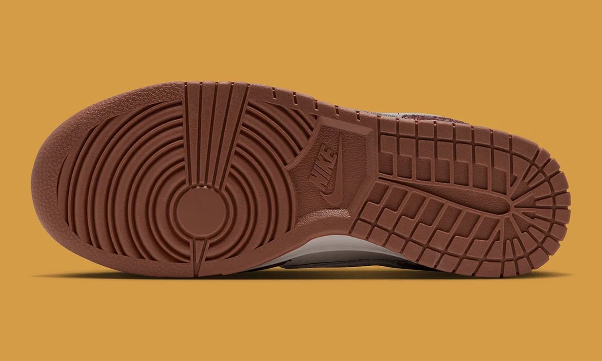 Outsole view, brown rubber with circular pivot pattern and tonal Nike logo on mustard background, Basketball Charm