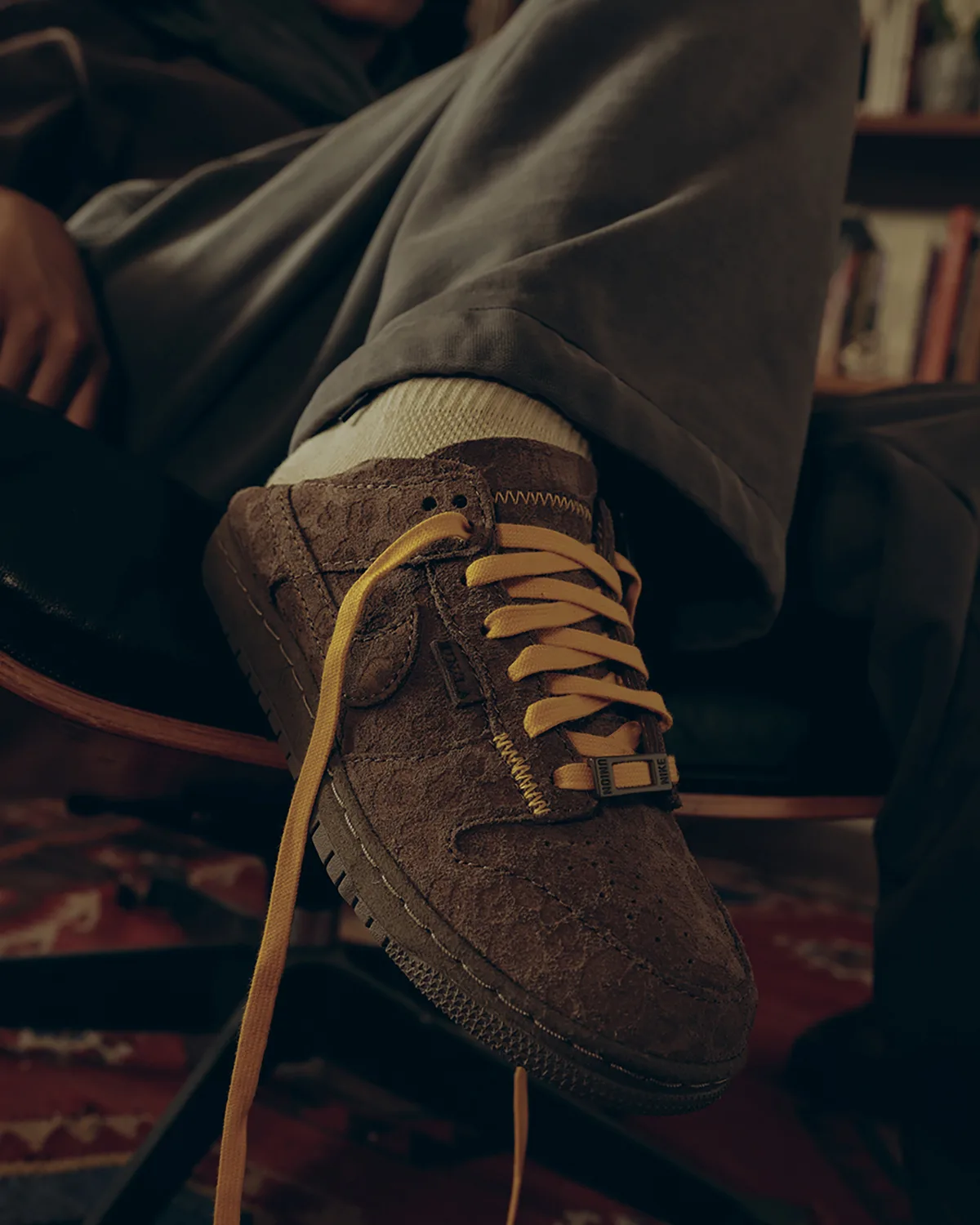 On-foot lateral view of brown textured suede low-top with mustard laces and Union Nike lace tag, Natural Selection
