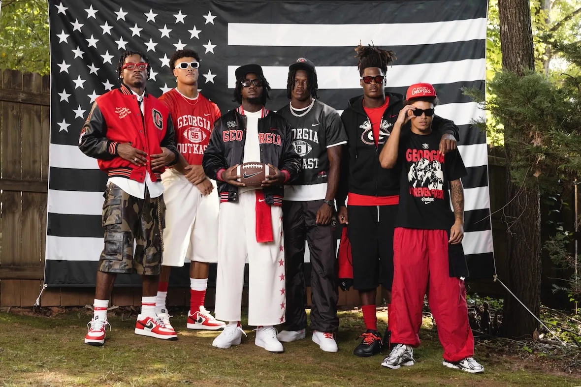 Six people posed before a black and white flag, red and white Georgia apparel and sneakers, Outkast Football Collection
