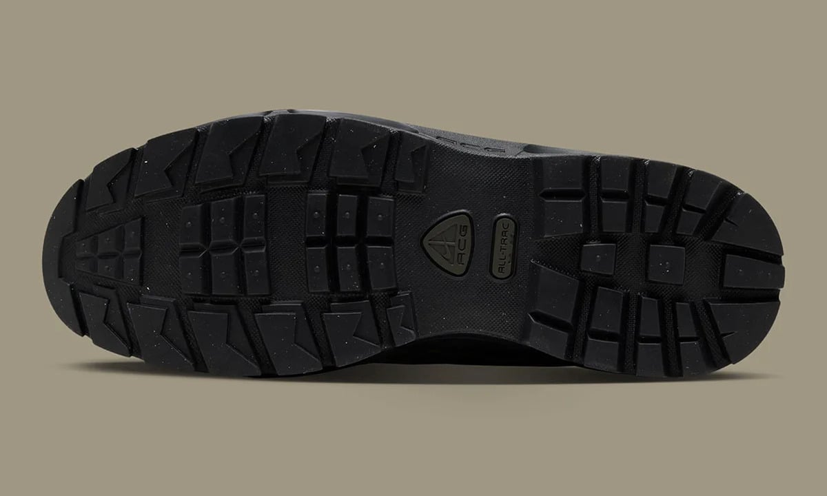 Outsole view, black lugged tread with ACG triangle logo and All-Trac badge, Metallic Gold
