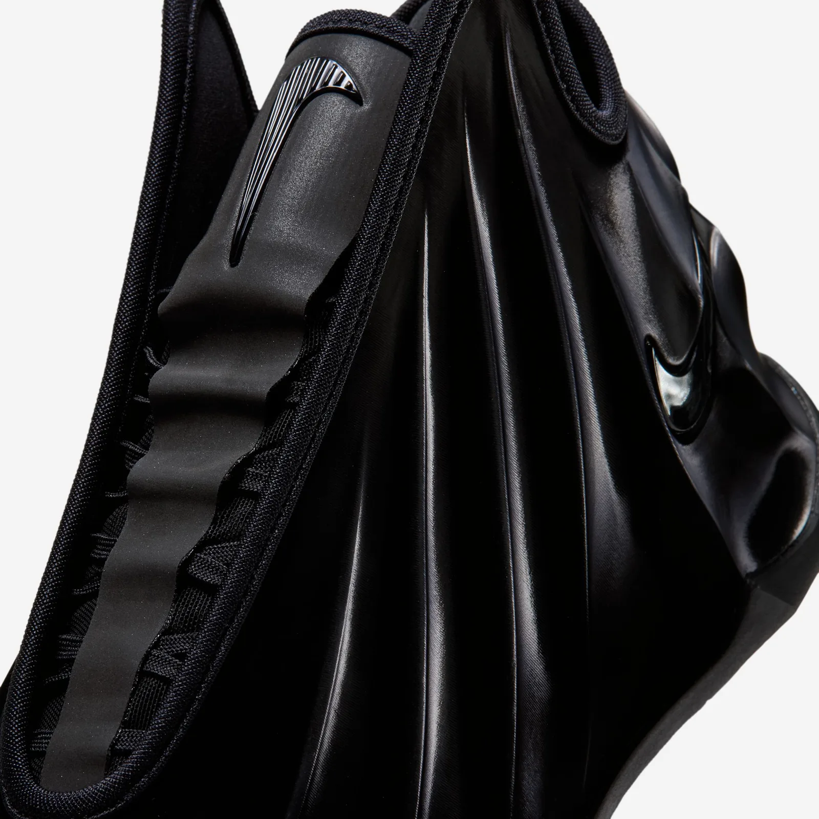 close-up of pull tab and ribbed collar lining, black swoosh, grey background, Triple Black