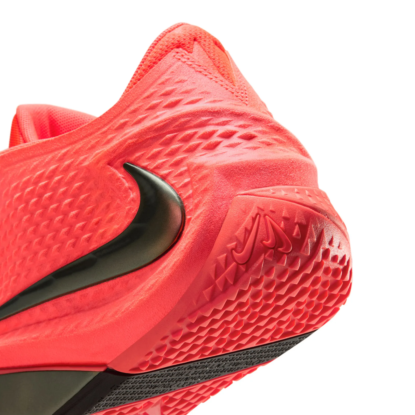 Heel detail with a glossy dark Swoosh and coral triangular outsole tread, Code Red