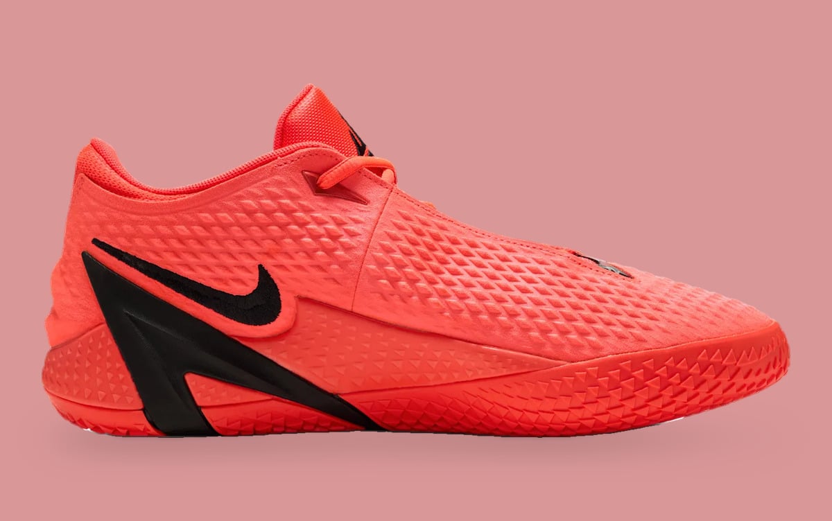 Medial view with a coral textured upper and embroidered black Swoosh, Code Red