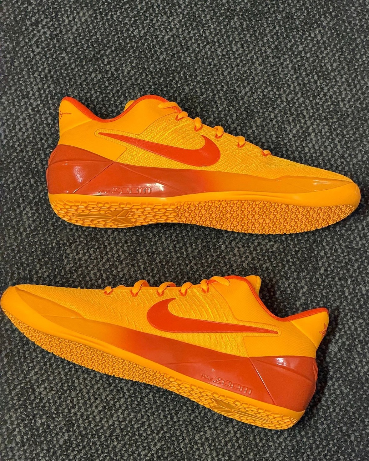 pair shown side by side, lateral view with orange Swoosh and Zoom Air text on outsole, Laser Orange
