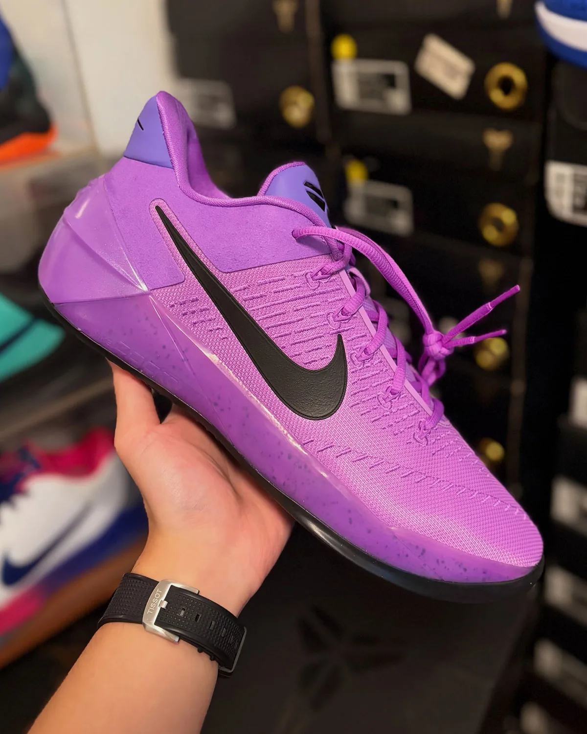 Lateral view in hand, purple-to-pink gradient upper, black swoosh, laces loose, Purple Stardust