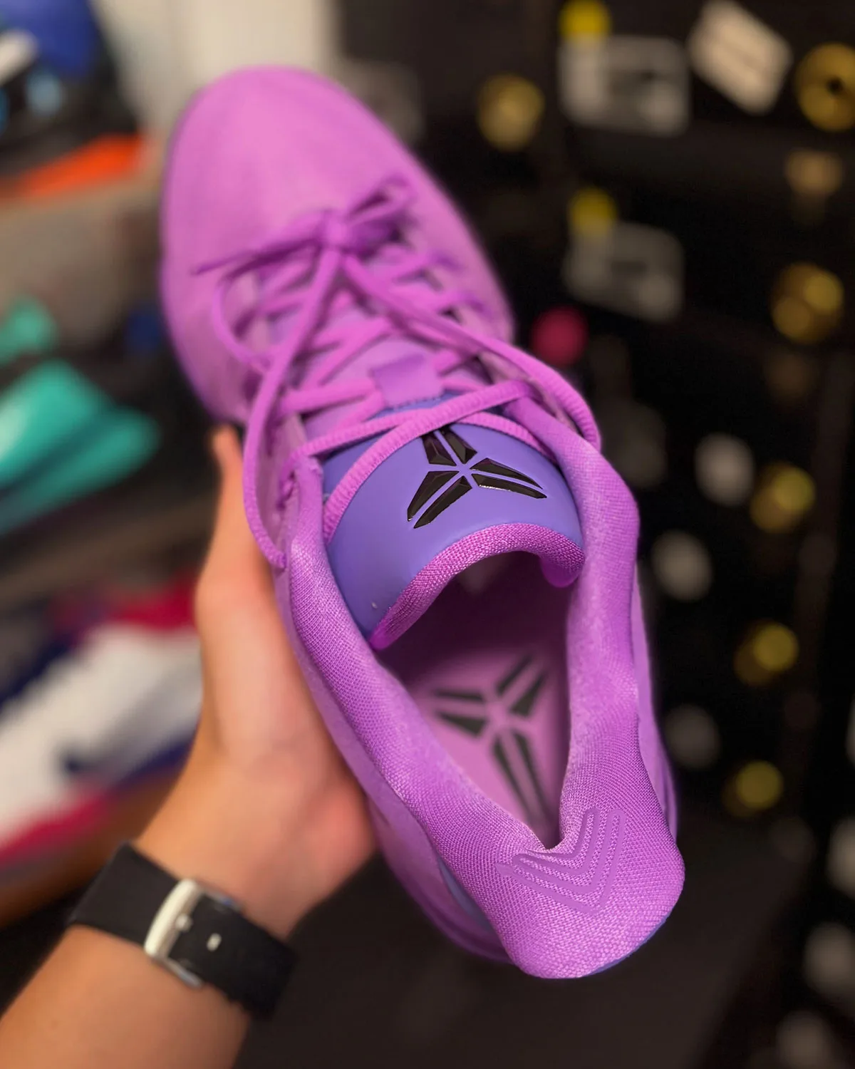 Top-down view, purple tongue with black Kobe sheath logo, pink insole below, Purple Stardust