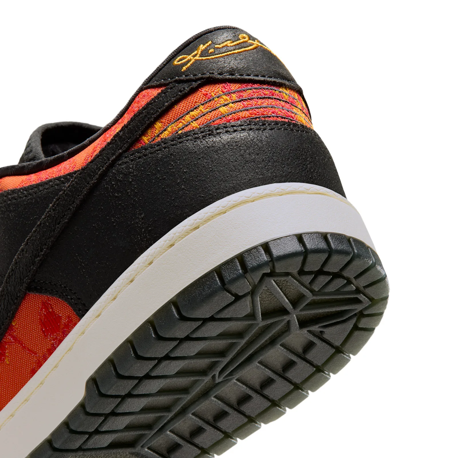Detail of heel and outsole, gold signature on black heel tab, striped red-orange panel, chunky tread, Mamba Eterno