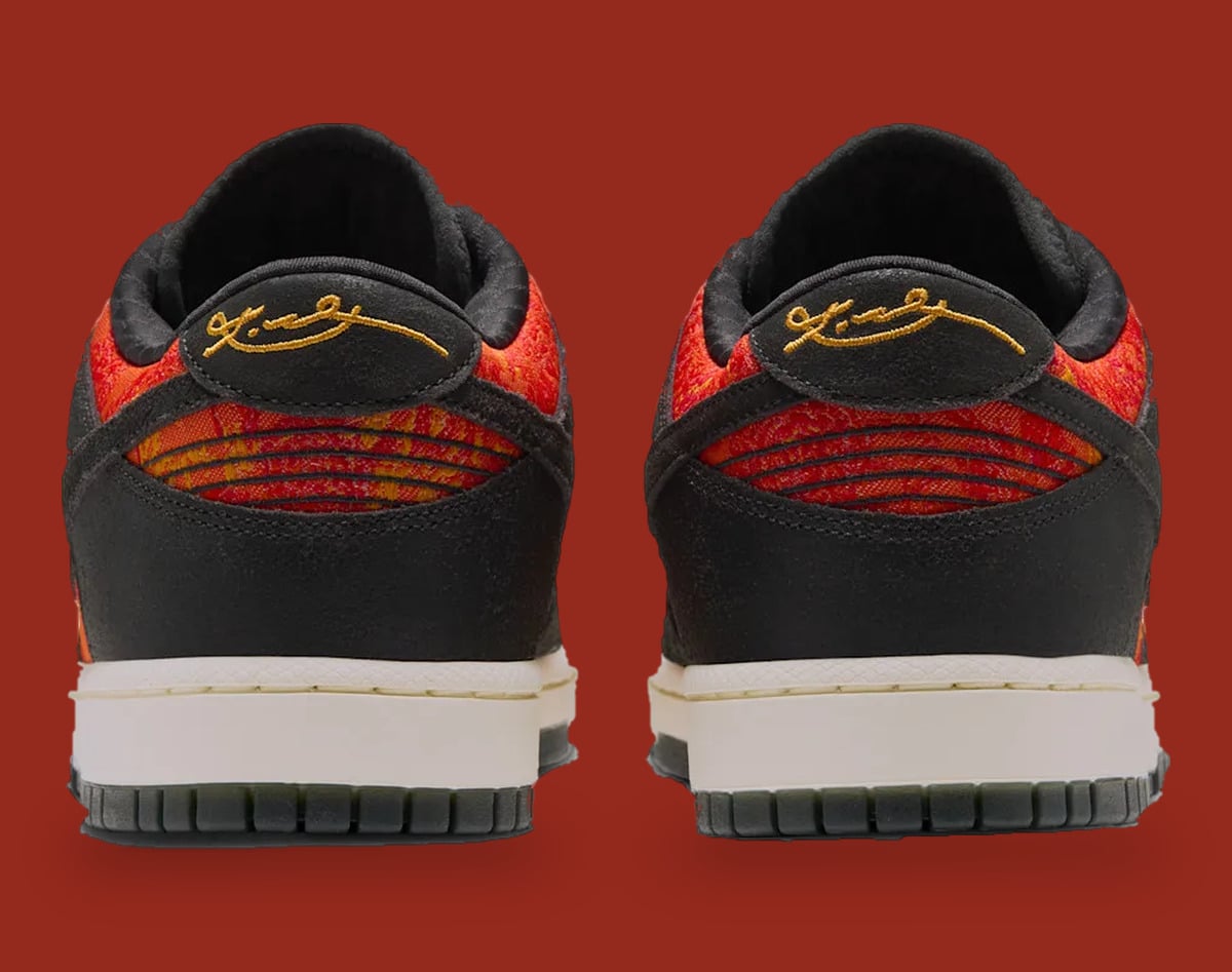 Heel view of pair, gold signature on black heel tabs, striped red-orange panels, cream midsole, Mamba Eterno