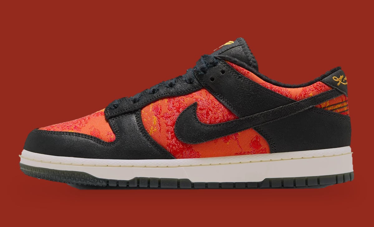 Lateral view, black swoosh over red-orange patterned panels, cream midsole, gold script on heel tab, Mamba Eterno