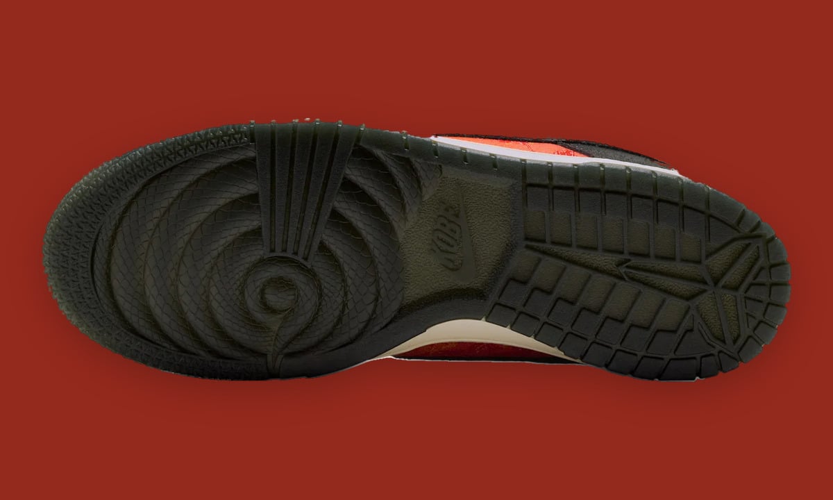 Outsole view, dark snakeskin-scale spiral at heel, textured tread at toe, small Kobe logo, Mamba Eterno