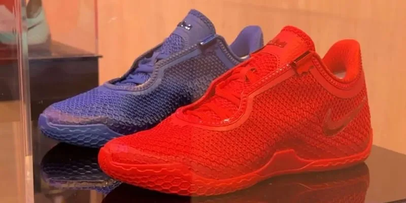 Pair of blue and red mesh sneakers, red lateral with tonal swoosh, in glass display case, Philadelphia 76ers Colorways