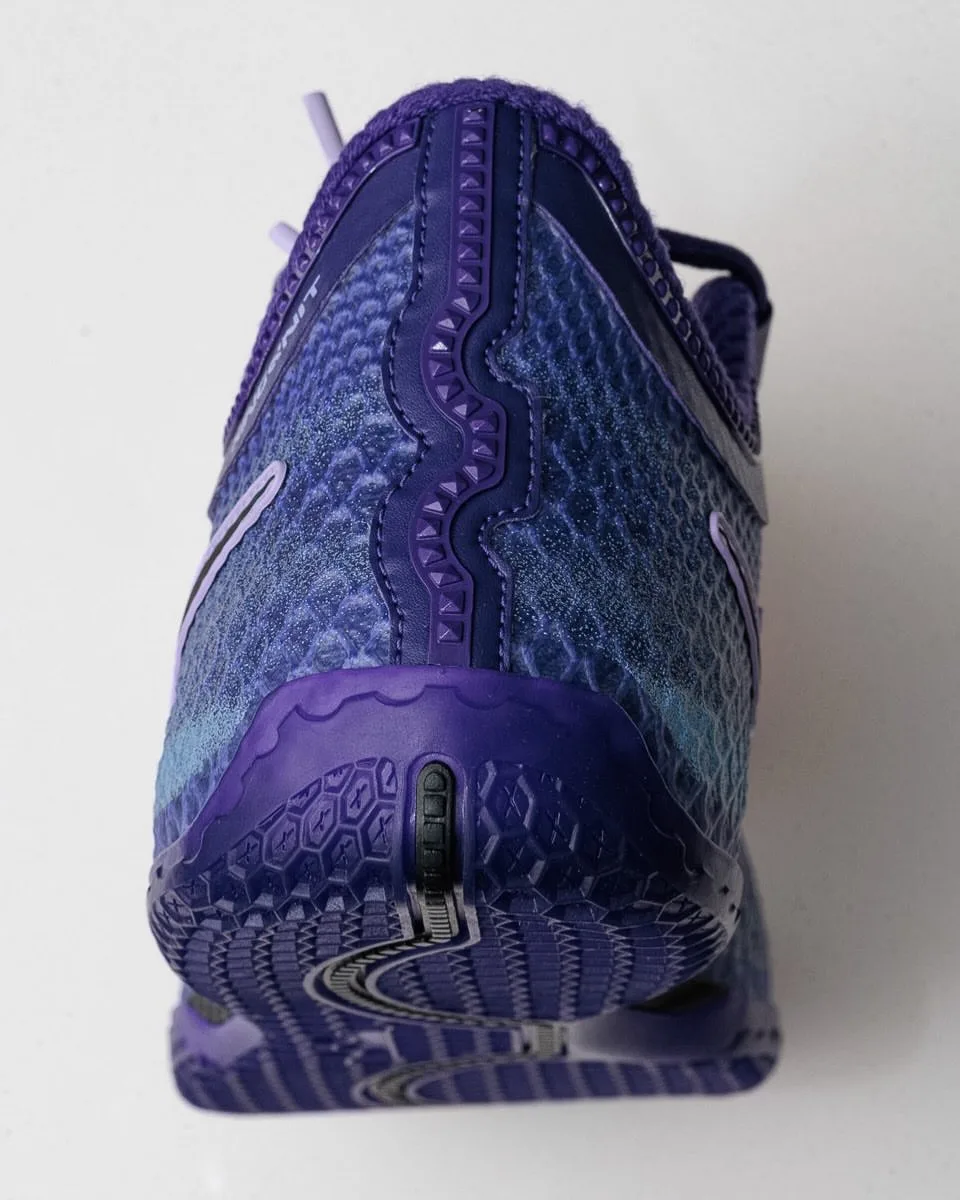 Heel and outsole view of purple sneaker with scaled blue upper and ridged purple sole, Opening Night
