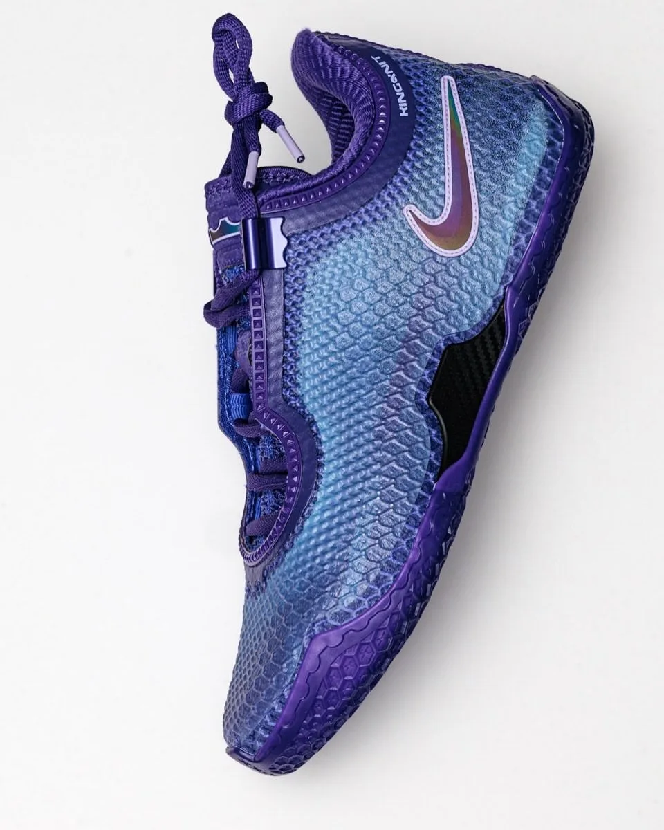 Lateral top-down view of purple and light blue scaled sneaker with iridescent swoosh on white, Opening Night