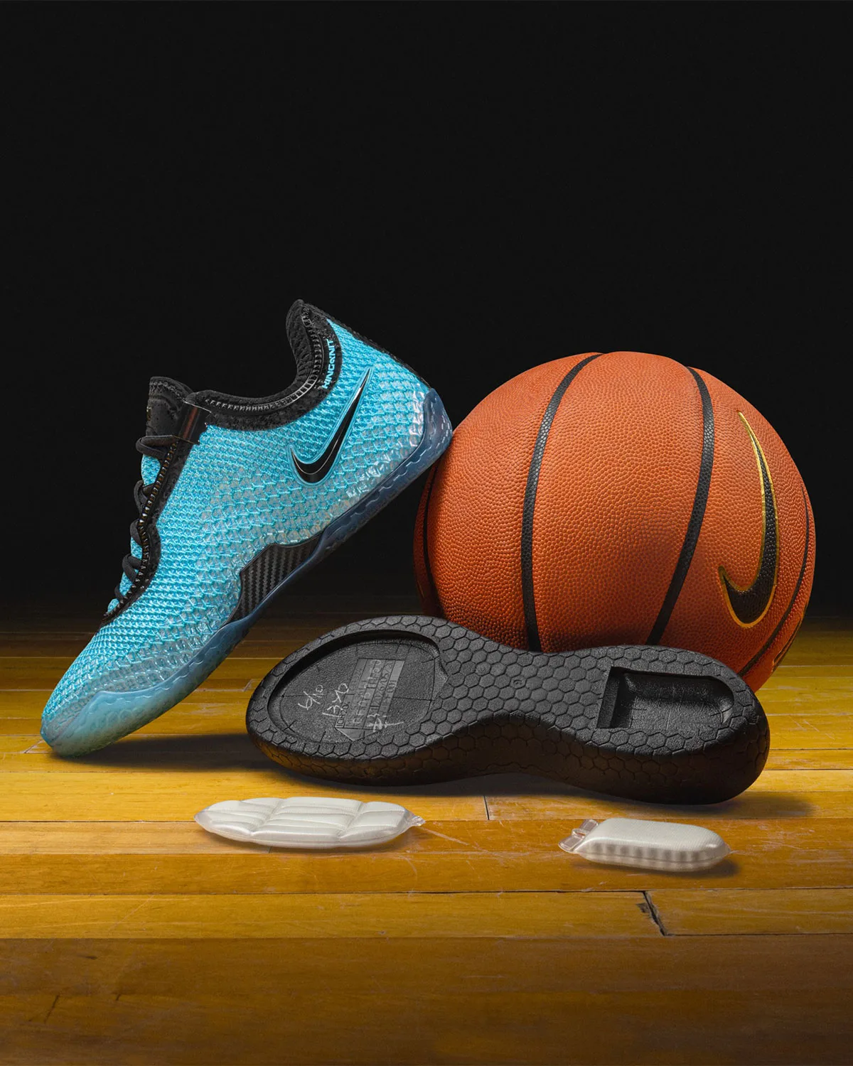 Blue knit shoe leaning on an orange basketball above a black midsole and foam inserts on a wood court, Stars