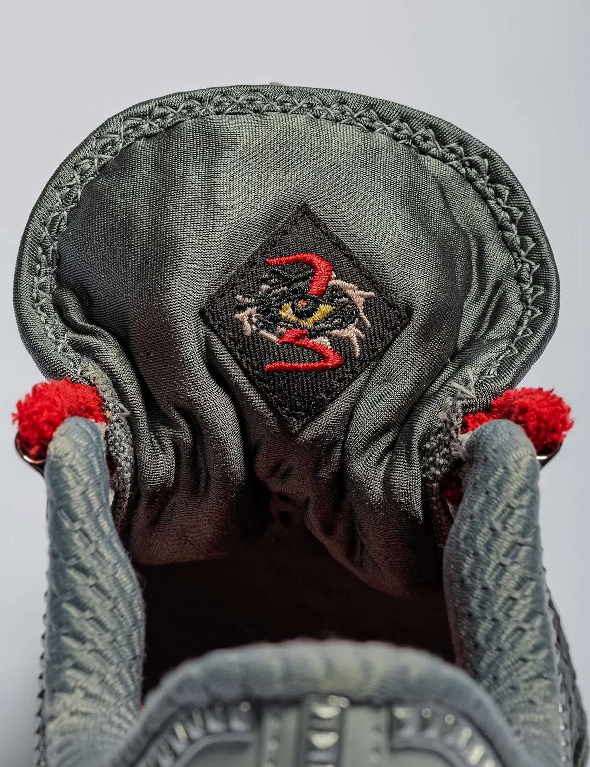 Detail of the inner collar lining with an embroidered red 3 and eye patch in a diamond, Storm Drain