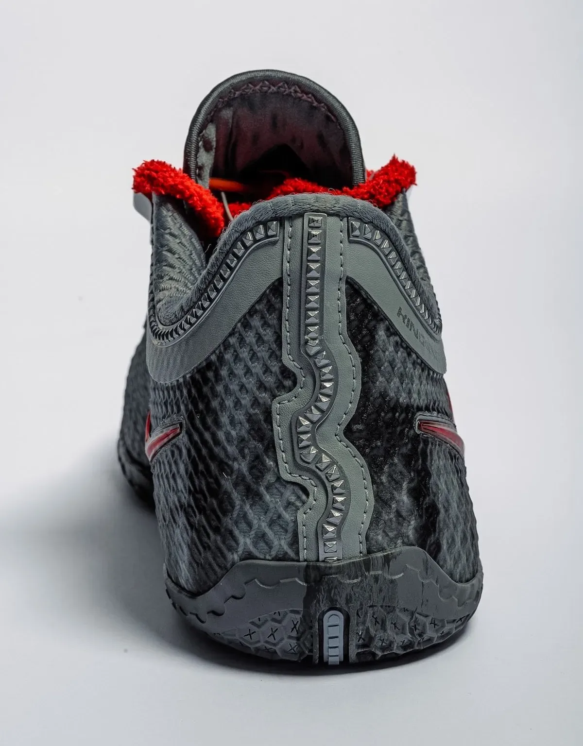 Heel view, dark grey textured upper with studded wavy stripe, red fuzzy collar and grey outsole, Storm Drain