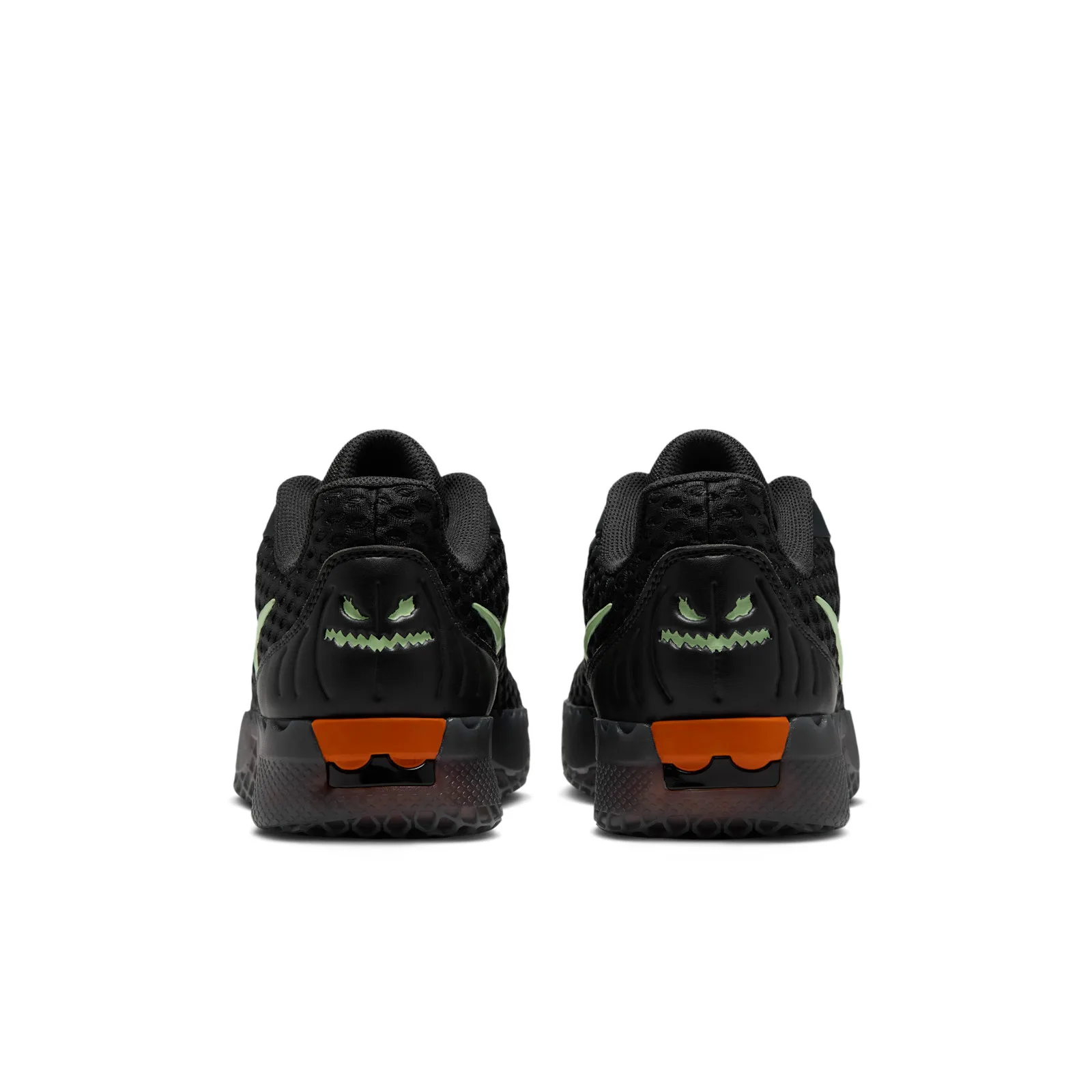 Heel view of pair with pale green jack-o’-lantern faces and orange sole accents, Halloween