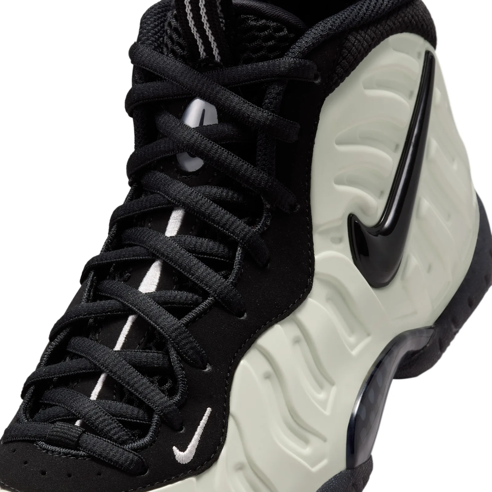 Detail of lacing, black laces and suede, white swoosh and glossy black swoosh on pale shell, Glow In The Dark