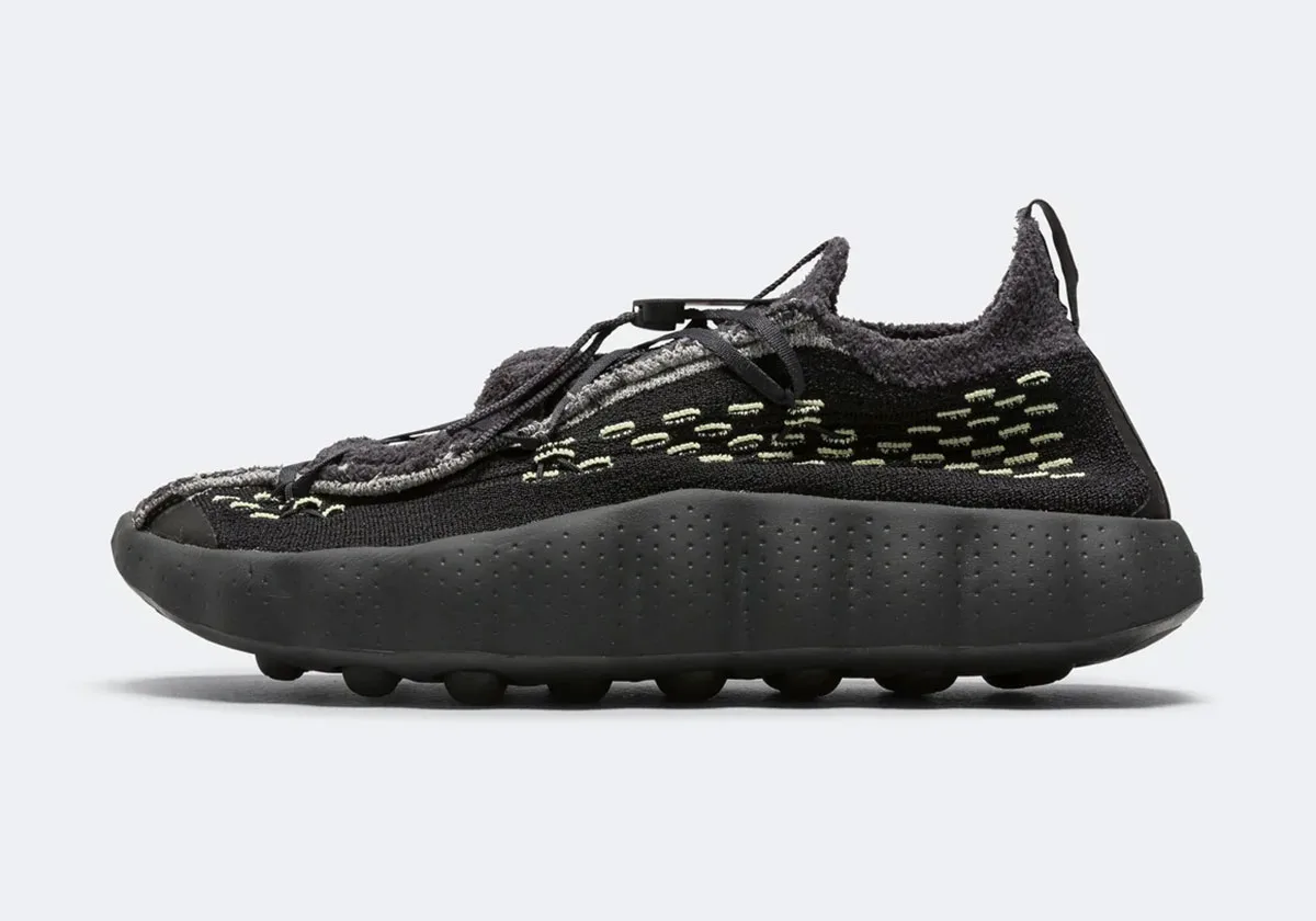 Lateral view on white, black fuzzy knit, pale green dashes and dotted midsole, Black/Dark Smoke Grey