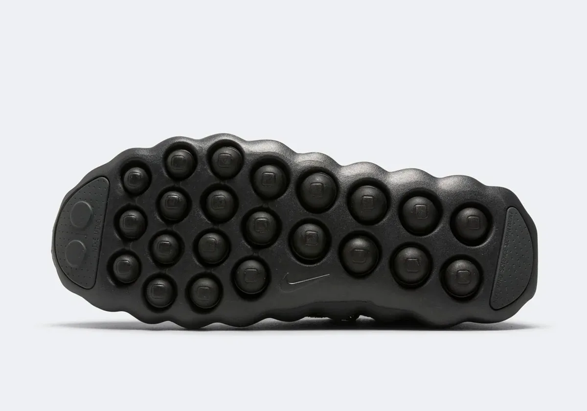 Outsole view, rounded black lugs, small Nike swoosh and grey heel and toe patches, Black/Dark Smoke Grey
