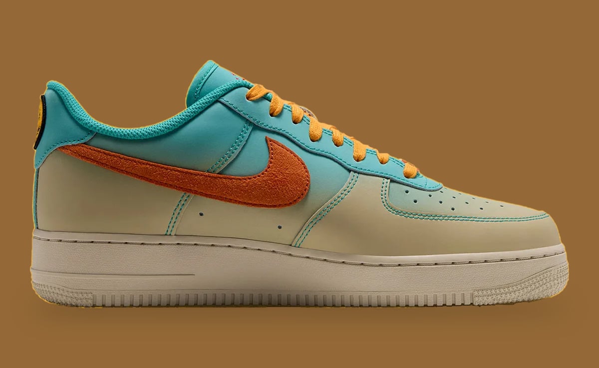 Side view, teal-to-cream gradient leather, orange suede swoosh, yellow laces, smiley heel patch, brown background, Holiday