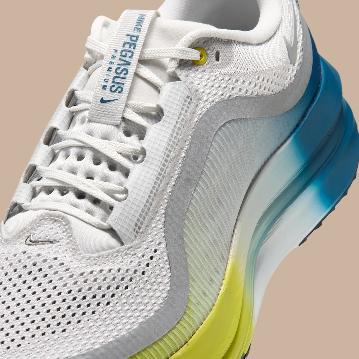 Detail of laces and tongue label reading Pegasus Premium, mesh and blue-yellow gradient midsole, The Perfect Texture For
