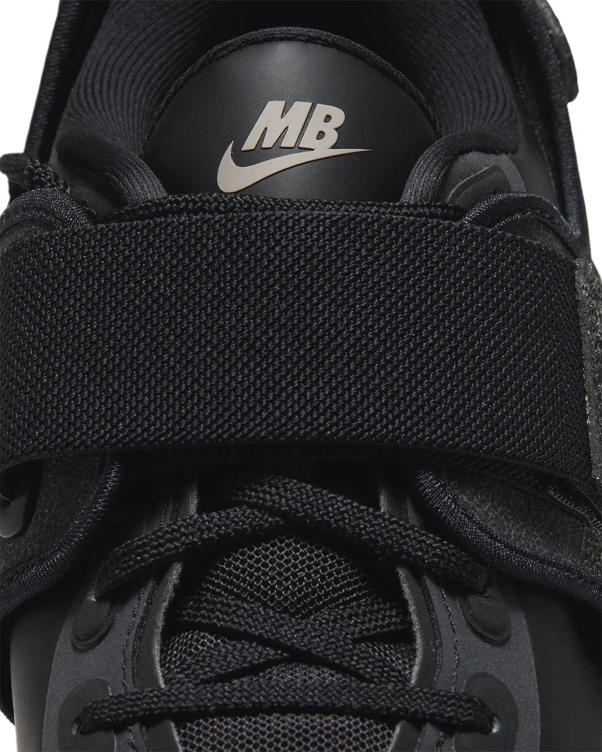 Tongue detail with a pale MB Swoosh logo above a wide woven black strap, Nike Rift Rocker