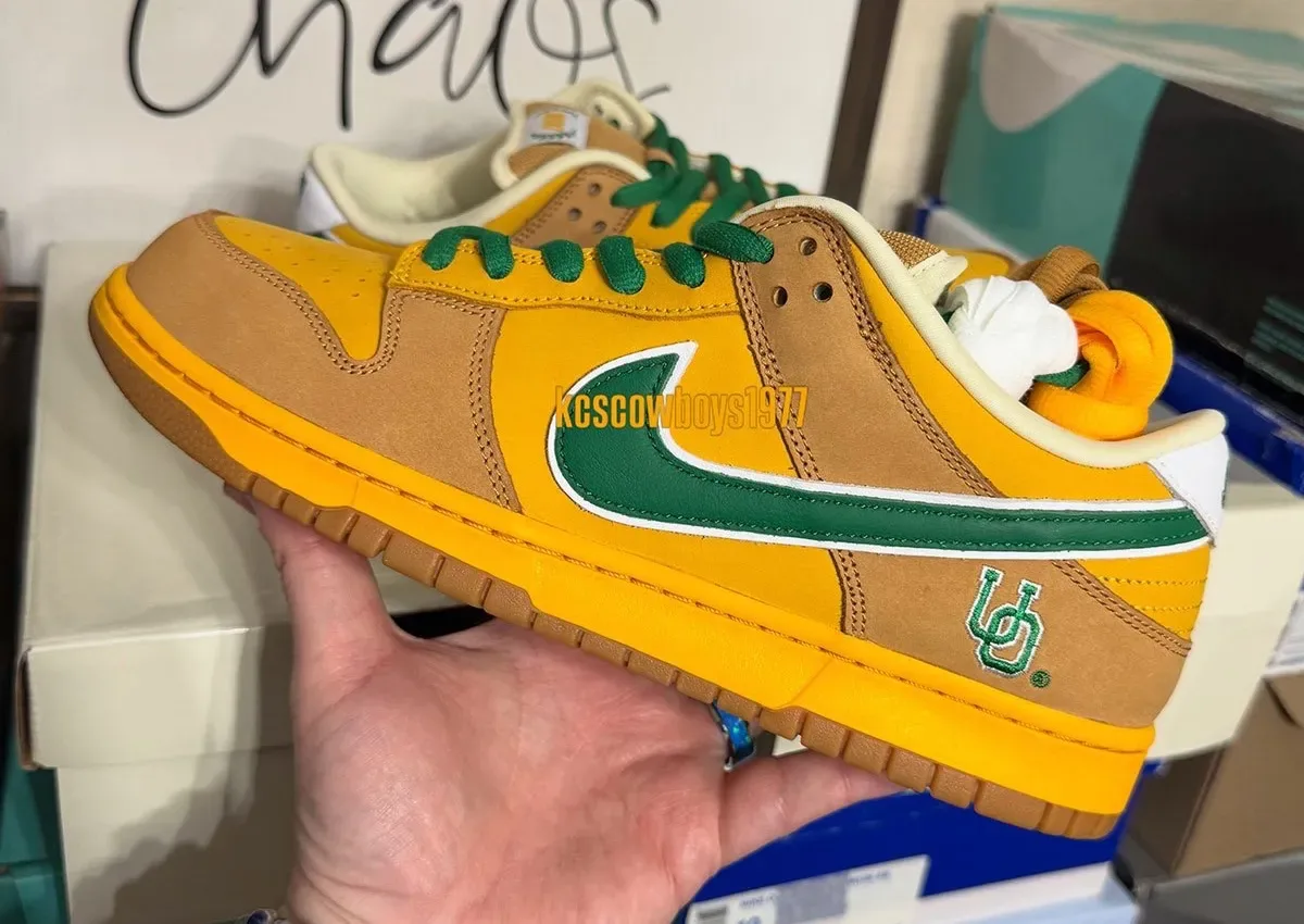 Lateral in-hand shot, yellow and tan suede, green swoosh, green laces, UO embroidery, Shout