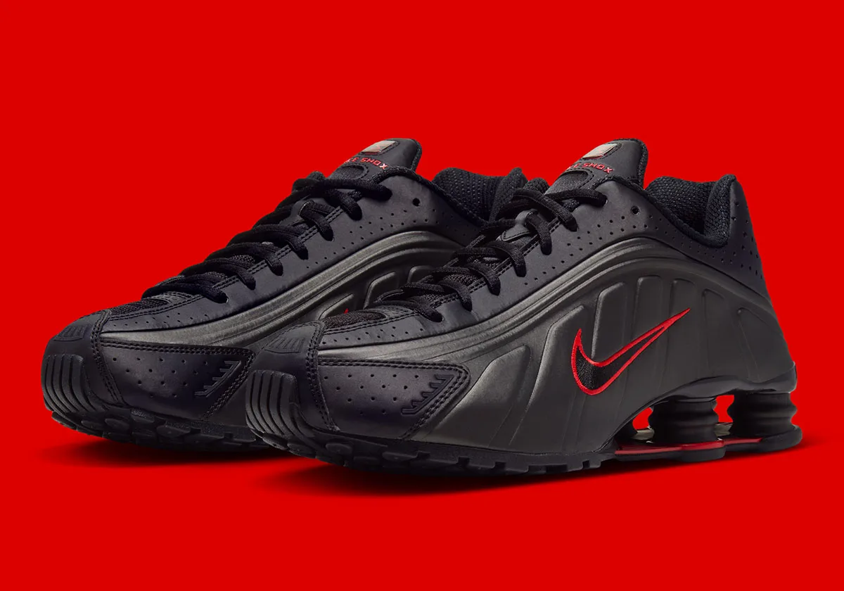 Three-quarter view of black pair with red-outlined Swooshes on red background, Black/Challenge Red