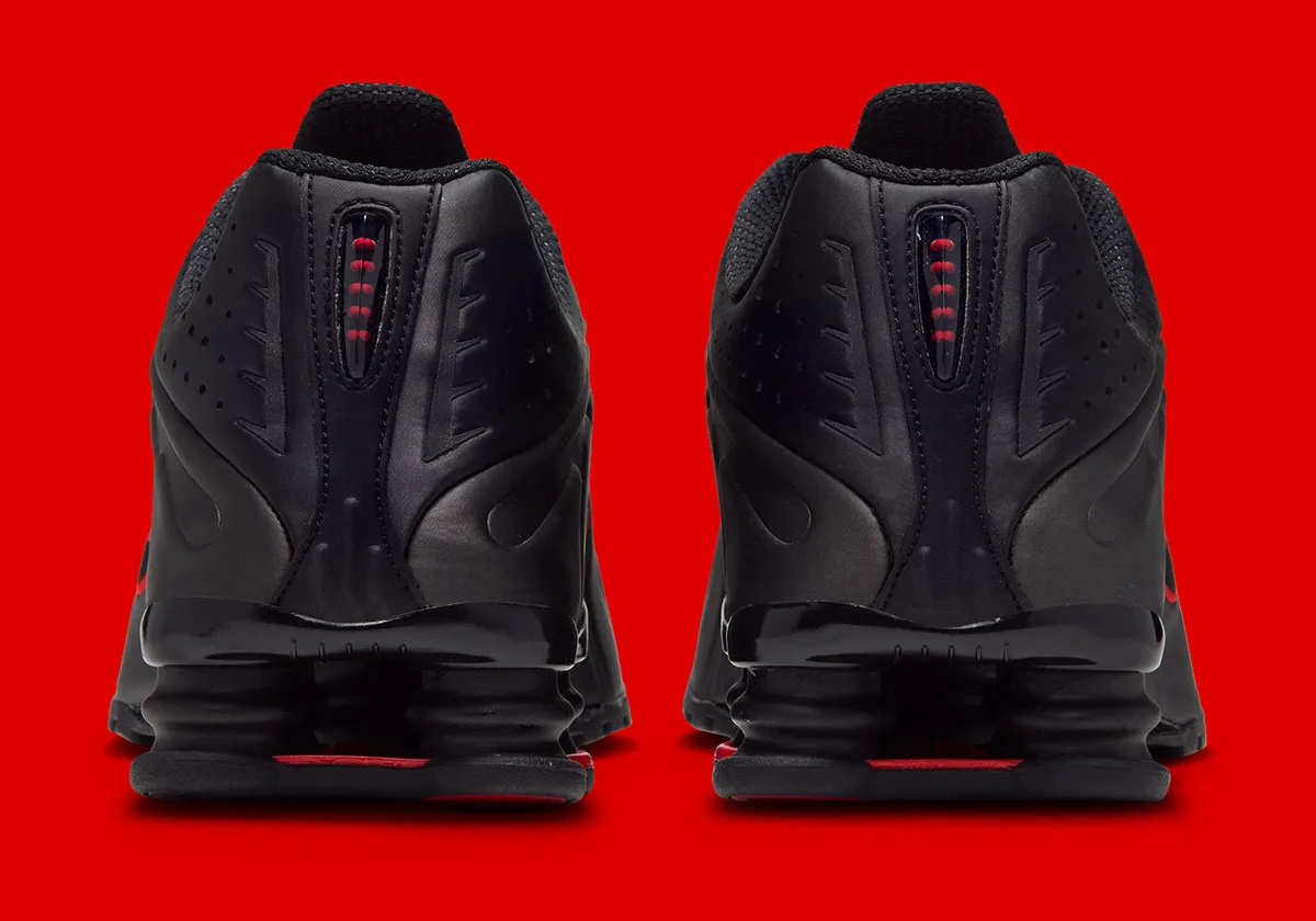 Heel view of pair with black cushioning columns and red accents in heel windows, Black/Challenge Red
