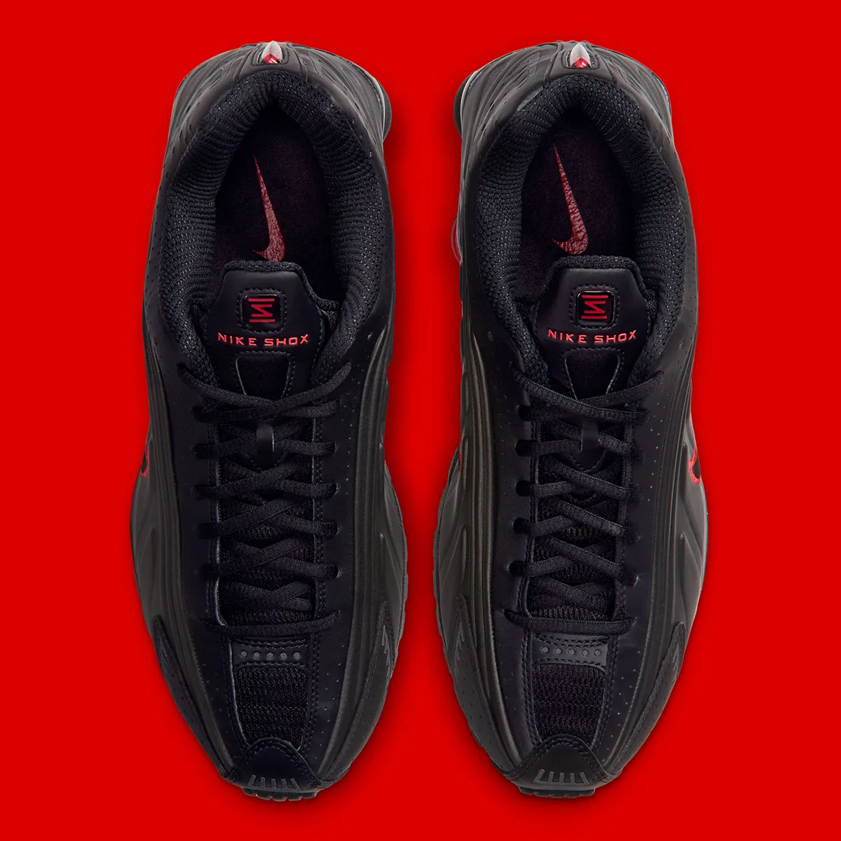 Top-down view of black pair with black laces and red Nike Shox tongue text, Black/Challenge Red