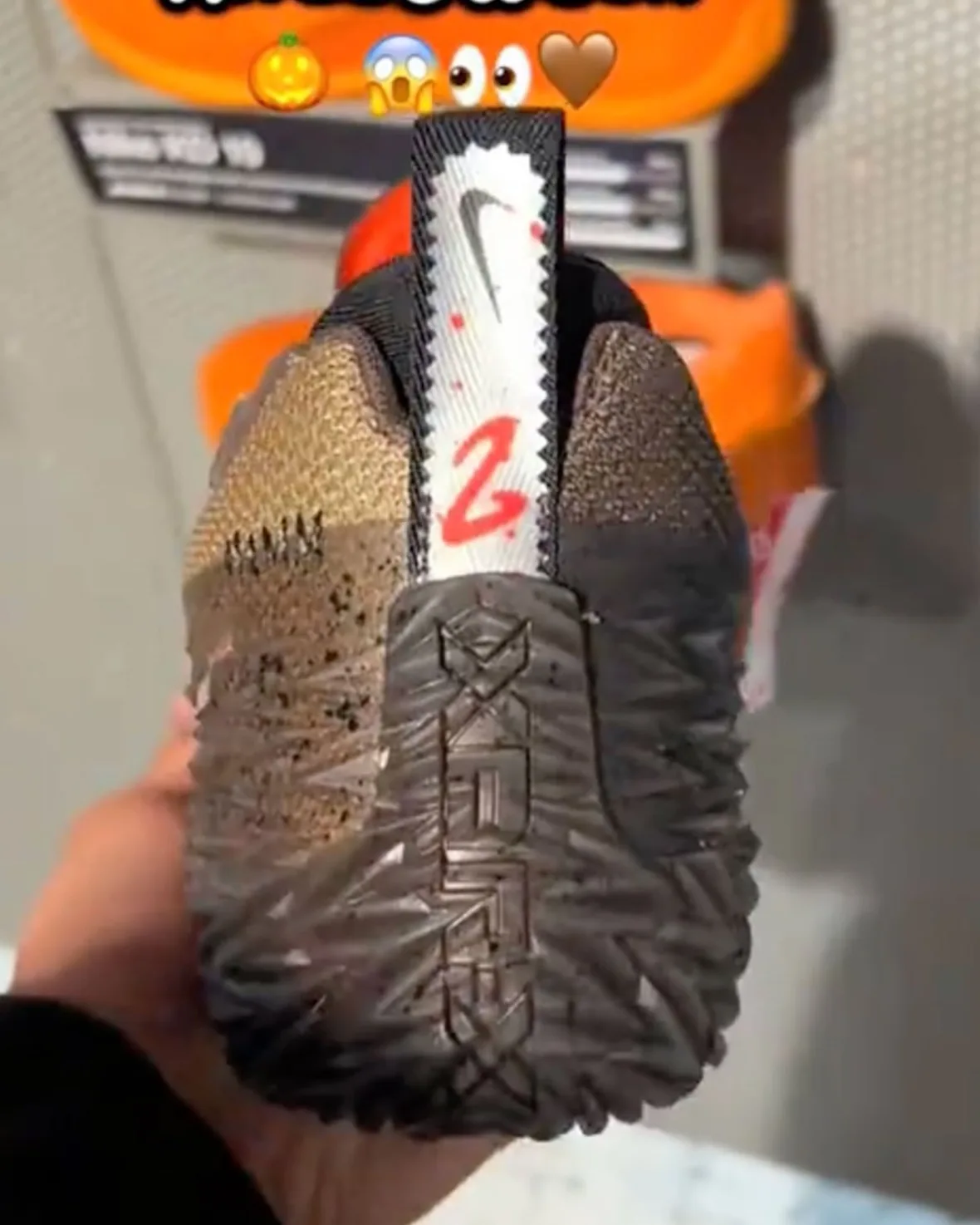 In-hand heel view with white serrated pull tab, red 2 and textured sole logo, Halloween