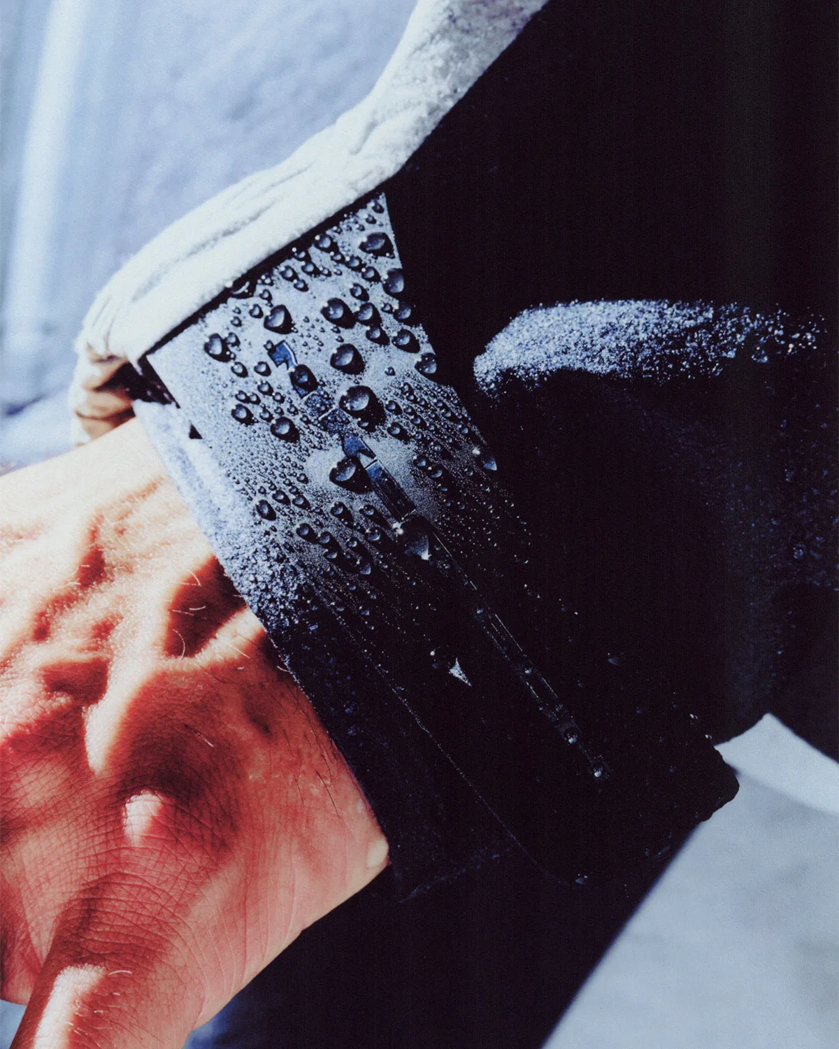 Detail of wrist and sleeve cuff in dark fabric beaded with water droplets, Boreas and SF3