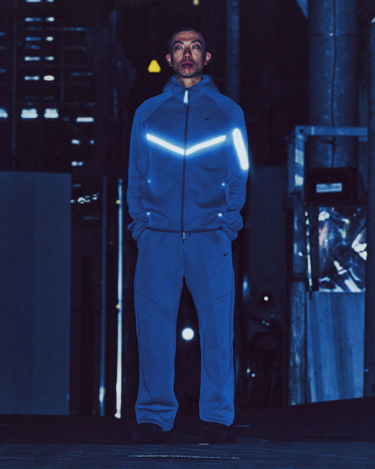 On-foot full-length night shot, blue hoodie and pants with glowing reflective chevron, Boreas and SF3