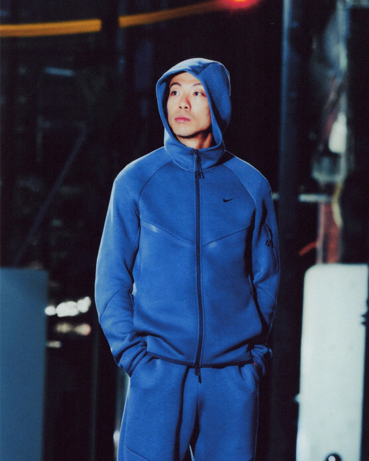 On-foot night shot, person in blue hoodie with hands in pockets and small black Swoosh, Boreas and SF3