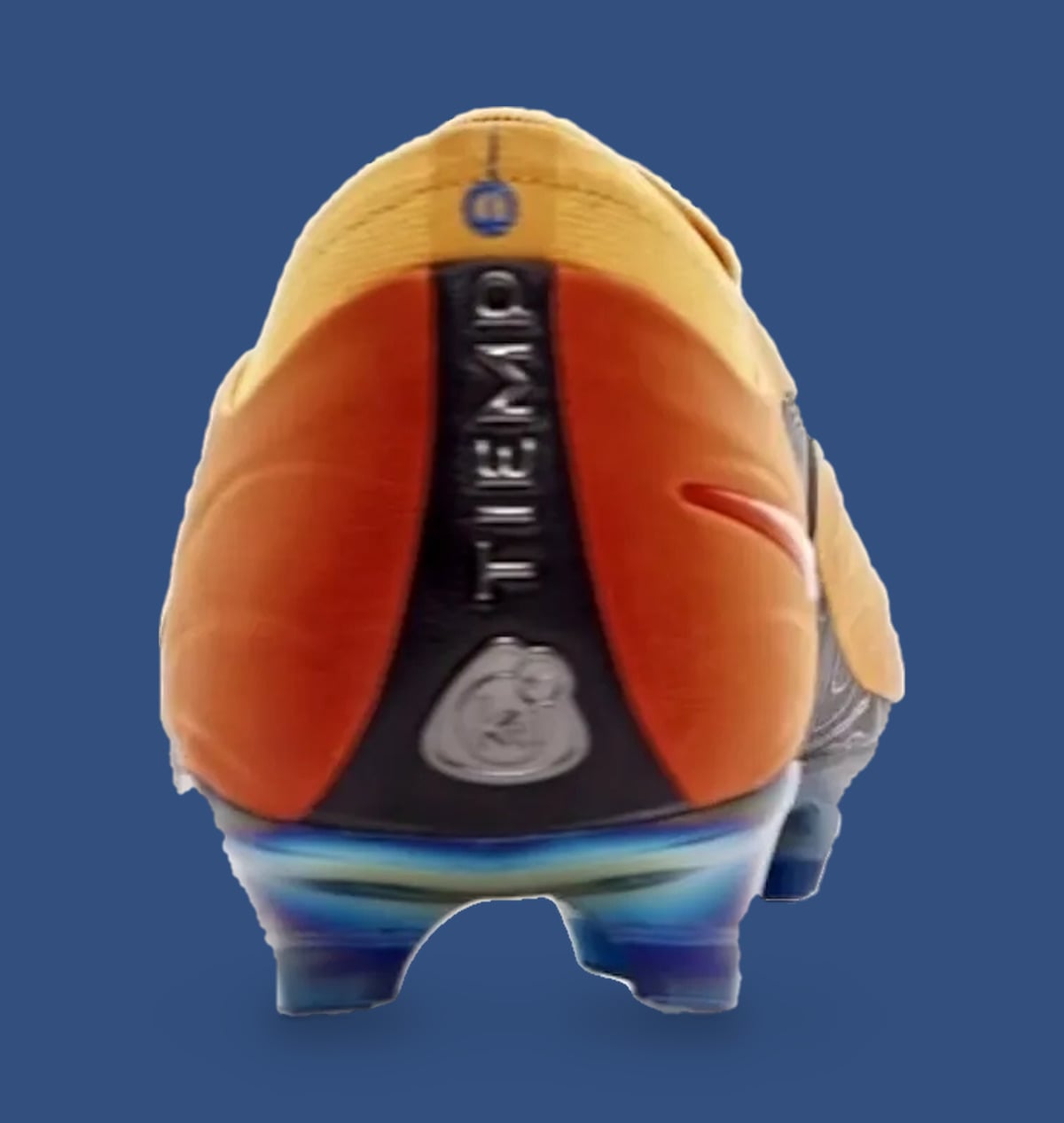 Heel view of orange boot with black heel stripe, vertical Tiempo text and silver badge, Sundial