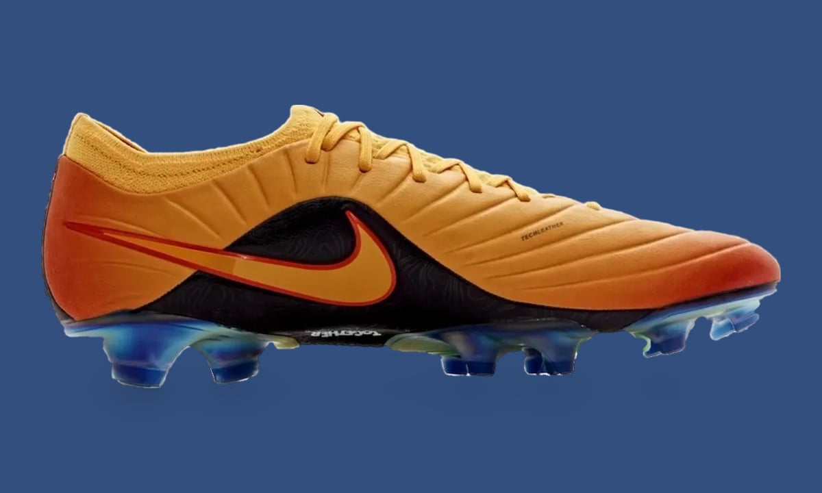 Lateral view of orange gradient leather boot with black side panel and swoosh, studs on dark blue backdrop, Sundial