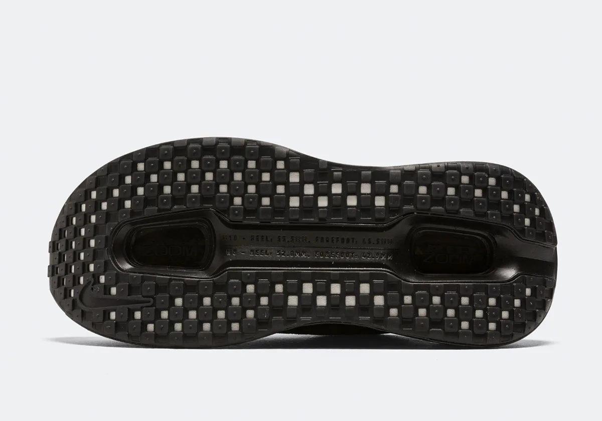 Outsole view of black square-lug tread with pale grey squares, Swoosh and Zoom windows, Skeleton