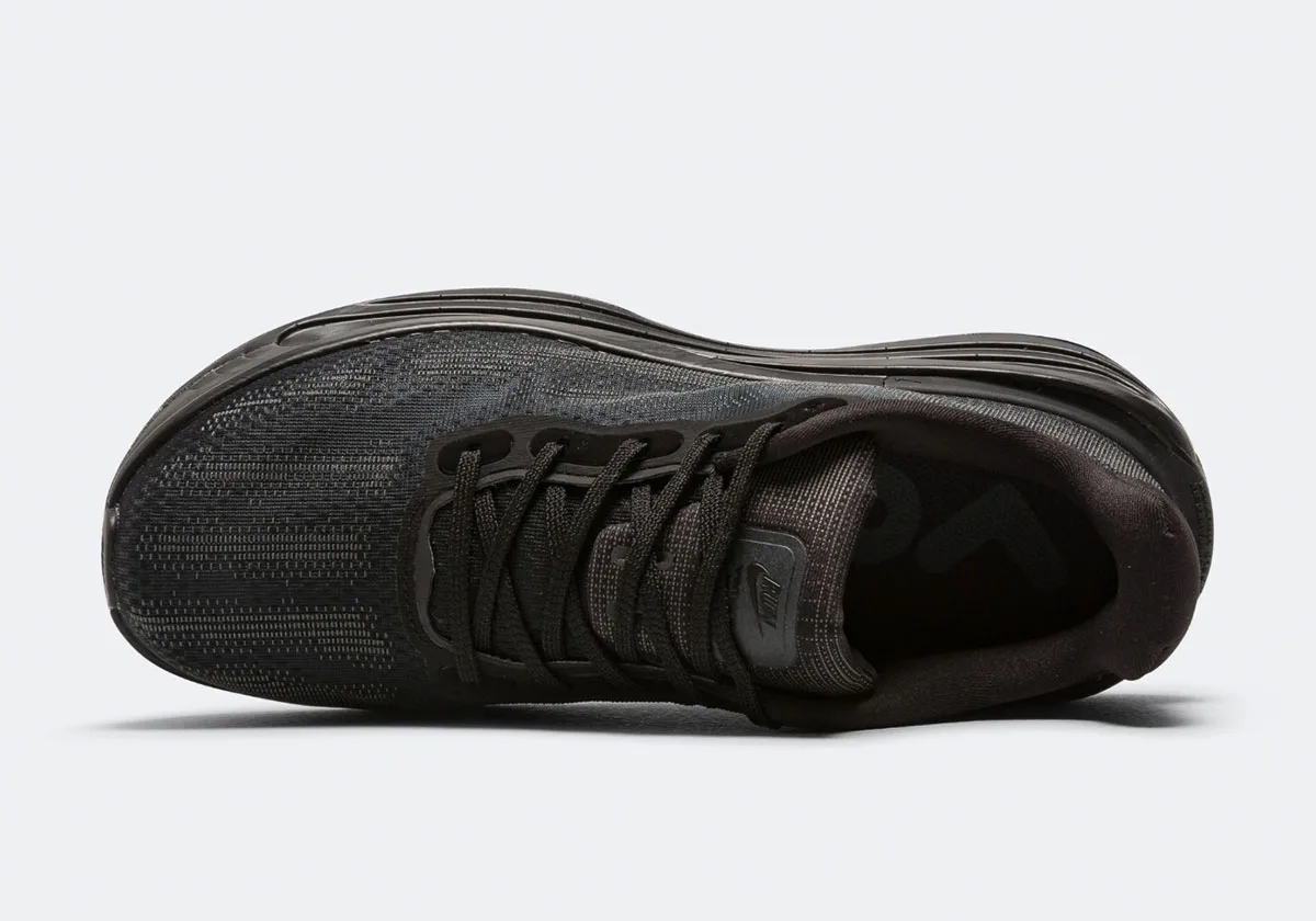 Top-down view of black mesh sneaker with black laces, small logo on tongue and dark lining, Skeleton
