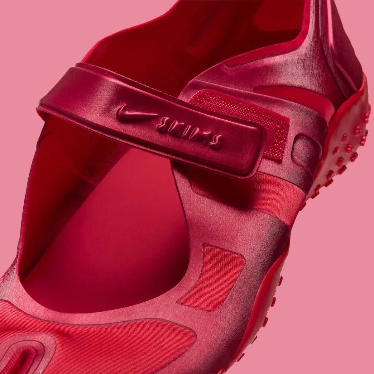 Strap detail, embossed Nike swoosh and Skims on red satin strap, red loop fabric, University Red