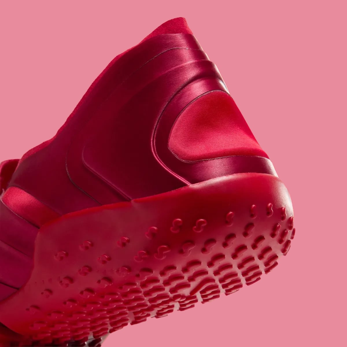 Heel detail, red satin heel panel above a thick red sole with raised nubs, University Red